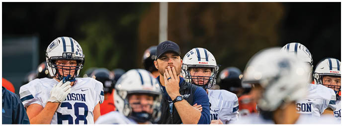A football player wearing a blue and white uniform. Description generated by AI