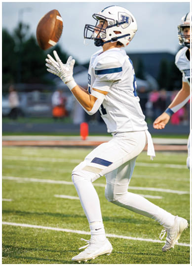 A football player wearing a blue and red jersey. Description generated by AI