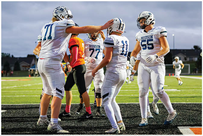 A group of football players wearing black and white uniforms. Description generated by AI