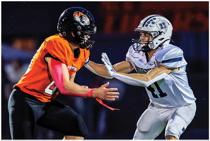 A group of football players wearing black and white uniforms. Description generated by AI