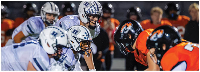 A group of football players on a field. Description generated by AI