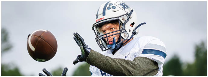 A football player wearing a blue and white uniform. Description generated by AI