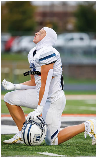 A football player catching a ball. Description generated by AI