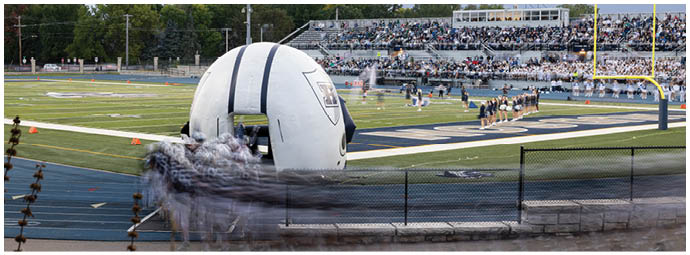 A football player wearing a blue and white uniform. Description generated by AI