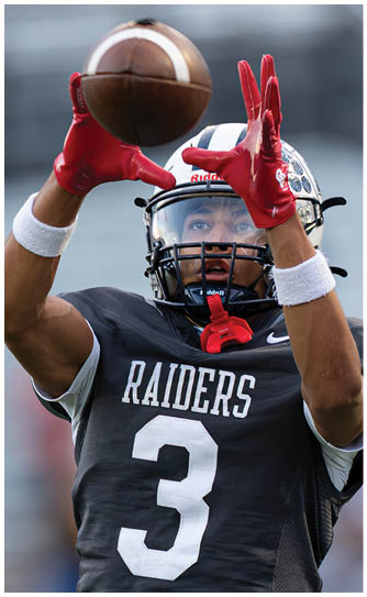 A football player catching a ball. Description generated by AI