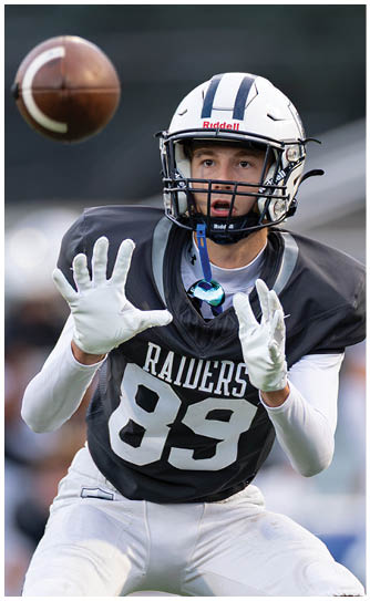 A football player catching a ball. Description generated by AI