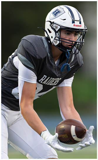 A football player catching a ball. Description generated by AI