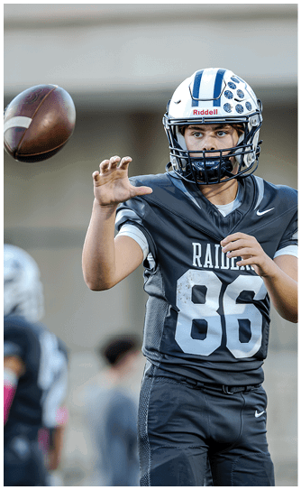 A football player catching a ball. Description generated by AI