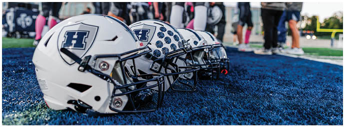 A football player wearing a blue and white uniform. Description generated by AI