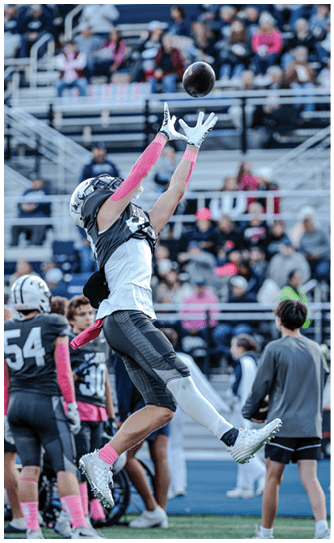 A football player catching a ball. Description generated by AI