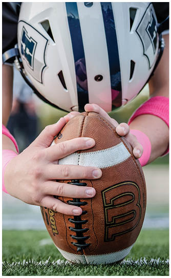 A football player catching a ball. Description generated by AI