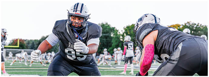 A football player wearing a blue and white uniform. Description generated by AI