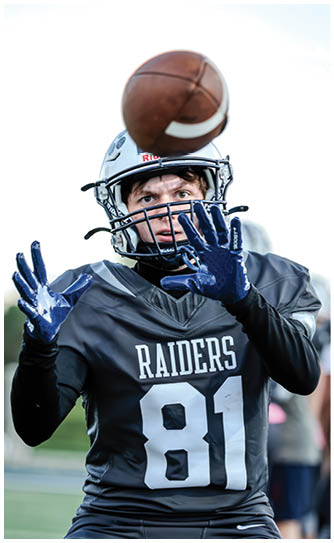 A football player catching a ball. Description generated by AI
