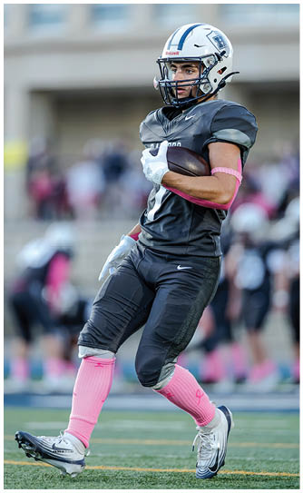 A football player catching a ball. Description generated by AI