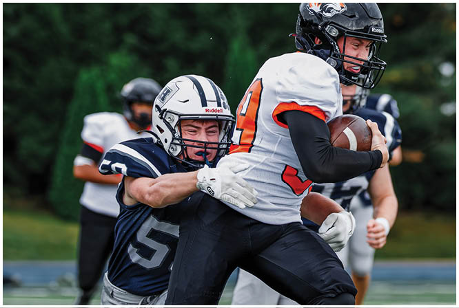 Three football players in blue and white uniforms running on a field. Description generated by AI