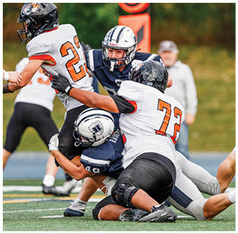 Three football players in blue and white uniforms running on a field. Description generated by AI