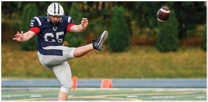 Three football players in blue and white uniforms running on a field. Description generated by AI