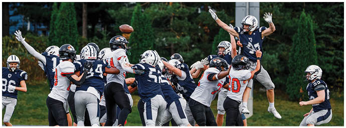 A football player wearing a blue and white uniform. Description generated by AI