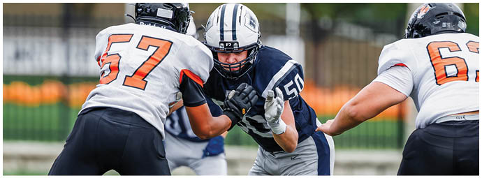 A football player wearing a blue and white uniform. Description generated by AI