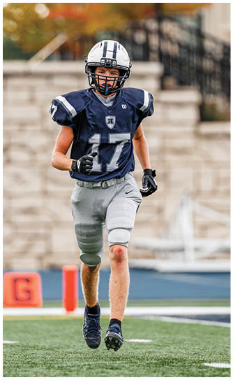 A football player catching a ball. Description generated by AI