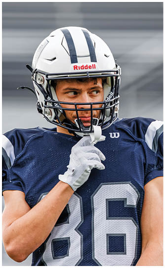 A football player catching a ball. Description generated by AI