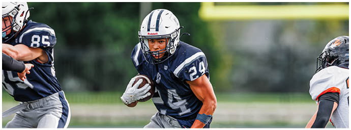 A football player wearing a blue and white uniform. Description generated by AI