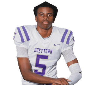 A person wearing a white and purple football uniform with the number five kneels with one knee on the ground against a white background. Description generated by AI