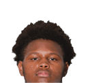Person with medium-length dreadlocks looking directly at the camera against a white background. Description generated by AI