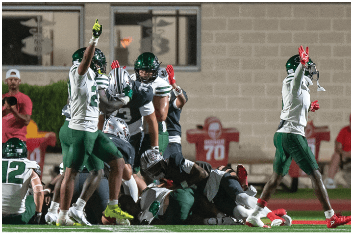 A group of football players on a field. Description generated by AI