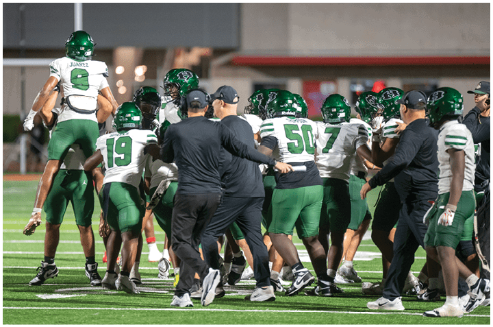 A group of football players on a field. Description generated by AI