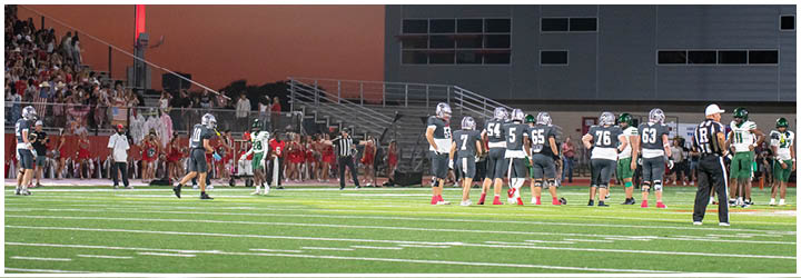 A football game is taking place on a field with players wearing blue and white uniforms. Description generated by AI