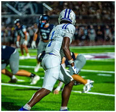 A football player running on the field. Description generated by AI