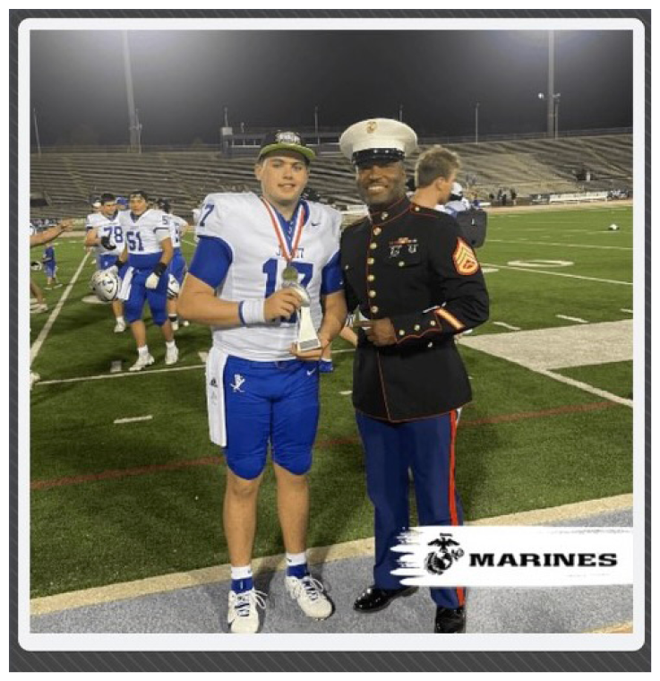Two football players wearing black jerseys and holding hands. Description generated by AI