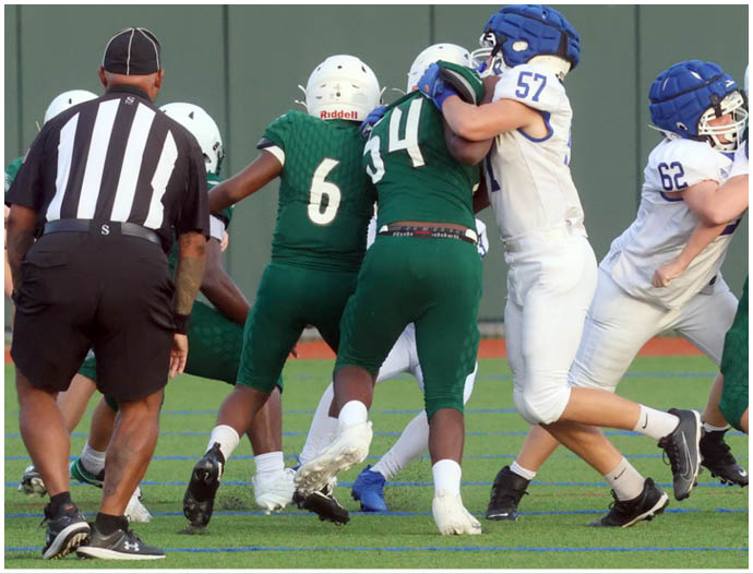 Three football players in blue and white uniforms running on a field. Description generated by AI