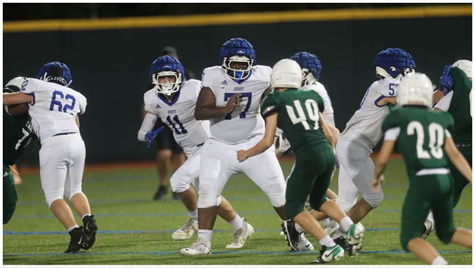 A football player wearing a blue and white uniform. Description generated by AI