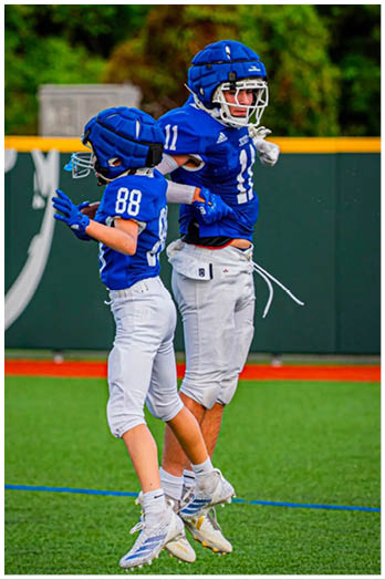 A football player catching a ball. Description generated by AI