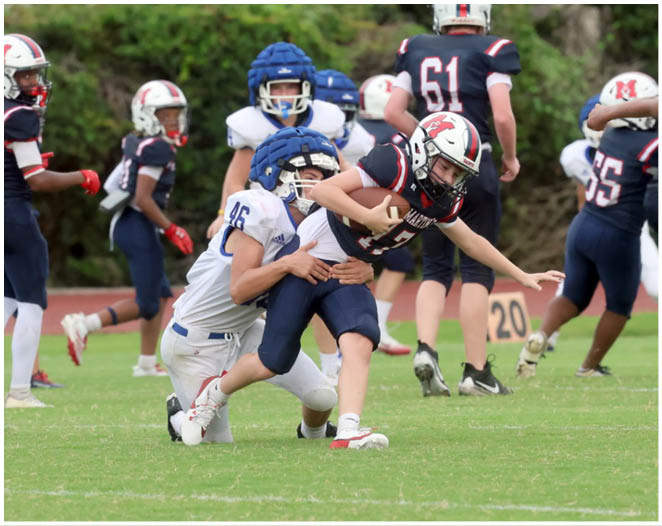 Three football players in blue and white uniforms running on a field. Description generated by AI