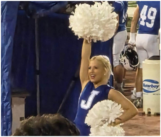 A football player wearing a blue and white uniform. Description generated by AI