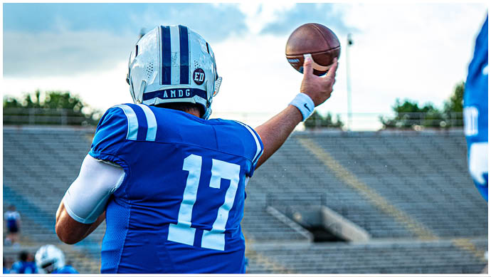 A football player wearing a blue and white uniform. Description generated by AI