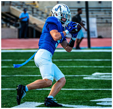 A football player running on the field. Description generated by AI