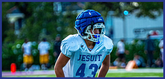 A football player wearing a blue and white uniform. Description generated by AI