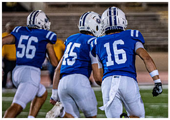 A group of football players on a field. Description generated by AI