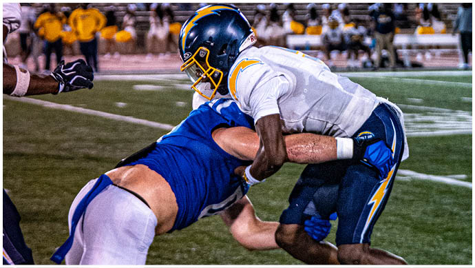 A football player wearing a blue and white uniform. Description generated by AI
