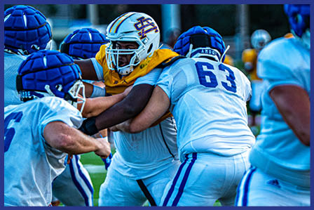 A football player catching a ball. Description generated by AI