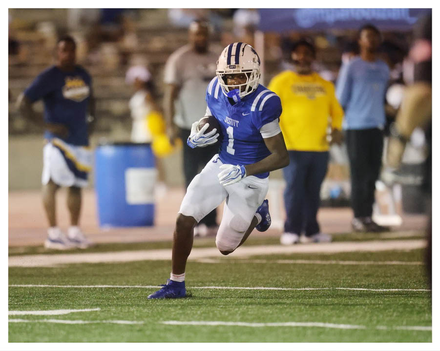 A football player wearing a blue and red jersey. Description generated by AI