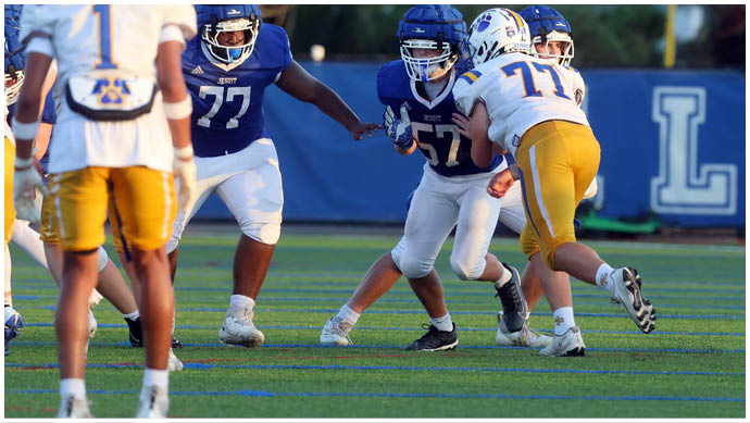 A football player wearing a blue and white uniform. Description generated by AI