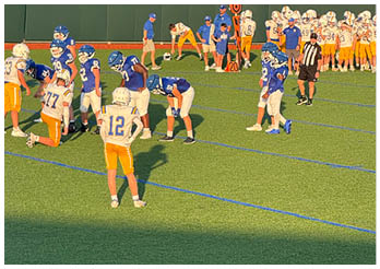 A group of football players on a field. Description generated by AI