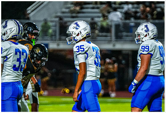 A football player wearing a blue and white uniform. Description generated by AI
