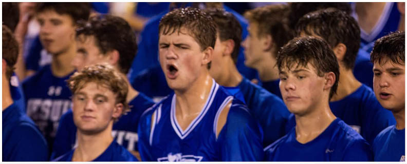 A football player wearing a blue and white uniform. Description generated by AI