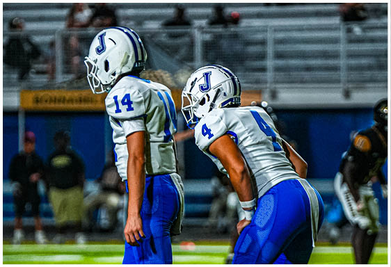 A football player wearing a blue and white uniform. Description generated by AI